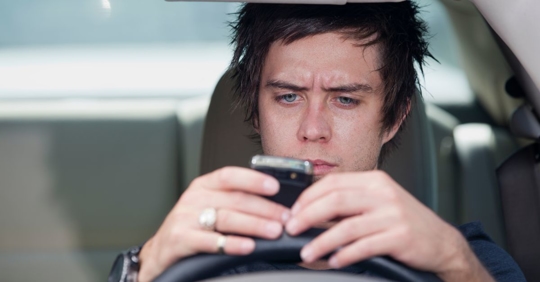 teen driver looking at phone
